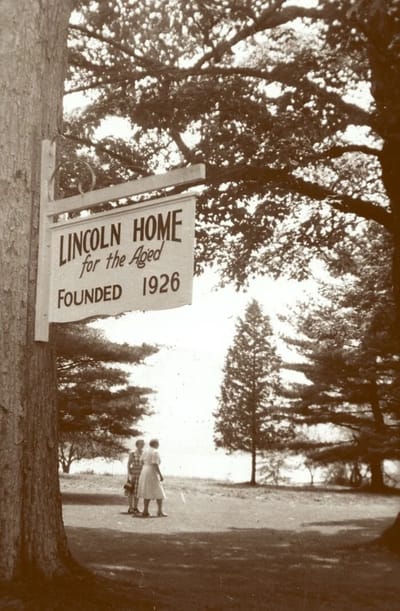 Sign of Lincoln Home with residents in view.