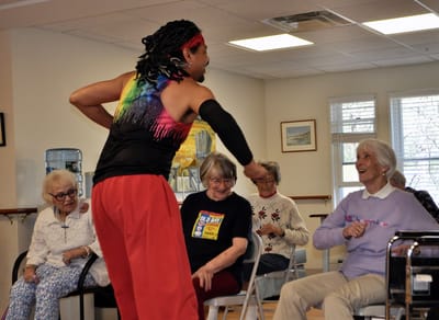 Residents enjoying a dance activity in a common area.