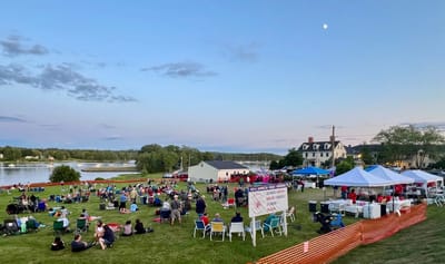 Community event with people gathered outdoors by water