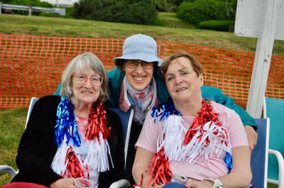 Three women celebrating outdoors with festive decorations.