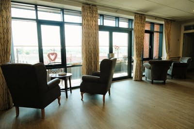 Cozy common area with armchairs and large windows
