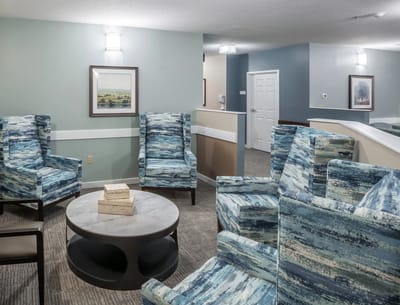 Common area with blue patterned chairs and a coffee table