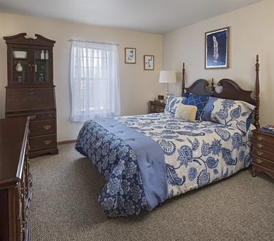 Cozy interior of a resident's bedroom with a floral bedspread