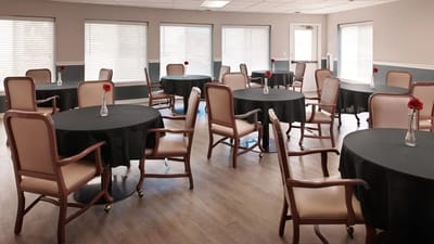 Bright dining area with tables and chairs set for residents.