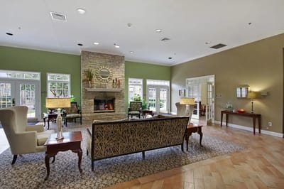 A cozy interior common area with a fireplace and seating