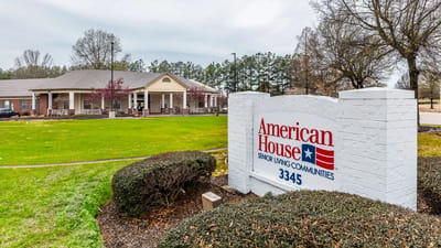 Entrance sign of American House Bartlett surrounded by landscaping