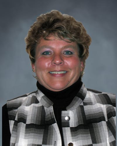 Portrait of a smiling woman in a patterned vest