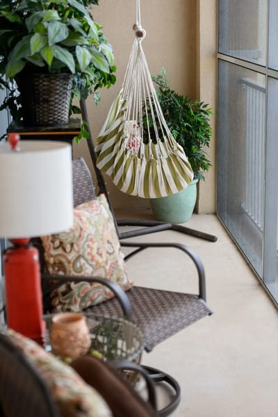 Cozy outdoor seating area with plants and hanging chair