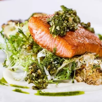 Close-up of a plated salmon dish with greens