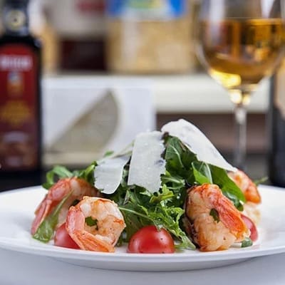 A gourmet salad with shrimp and wine