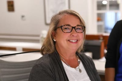 A smiling staff member at the facility's reception area