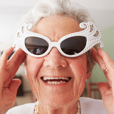 Senior woman smiling while wearing unique sunglasses