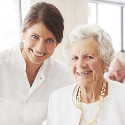 A staff member smiling with a resident in a common area