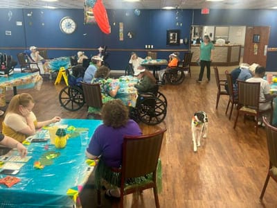 Residents enjoying an activity in a common area with a dog
