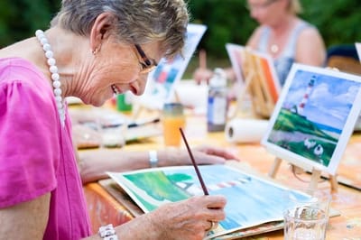 Resident engaged in a painting activity at a table