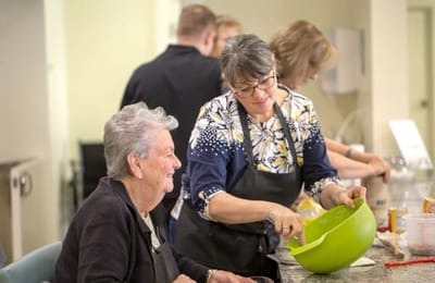 Residents participating in a cooking activity with staff