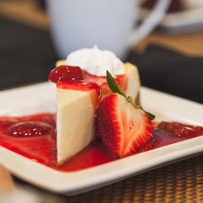 Cheesecake topped with strawberries and sauce