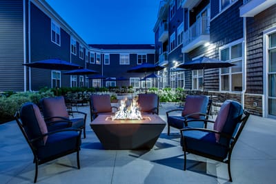 Outdoor seating area with a fire pit in the evening