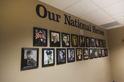 Gallery wall honoring veterans with framed photographs