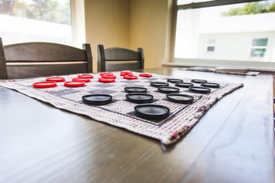 Checkers game set up on a dining table with chairs