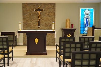 Interior view of a chapel with altar and stained glass