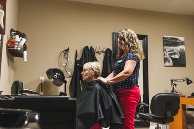 A resident receiving a haircut in the salon