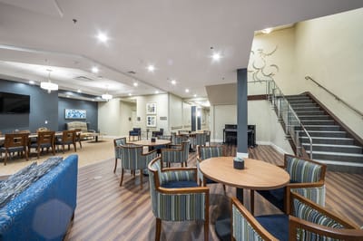 Bright common area with seating and piano