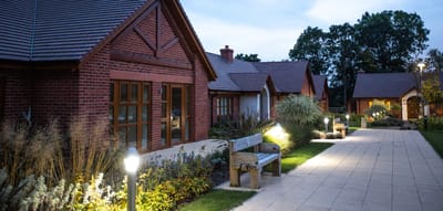 Pathway with lighting and benches outside residential buildings