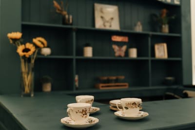 Decorative tea cups on a green counter in a common area
