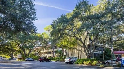 View of the facility's exterior with trees and parking