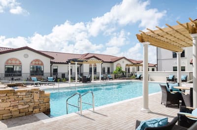 Outdoor pool area with lounging chairs and umbrellas