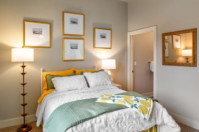 Brightly decorated private resident room with bed and artwork