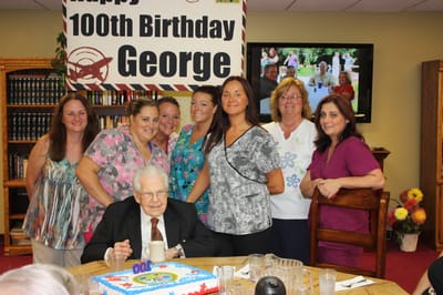 Residents and staff celebrating a 100th birthday.