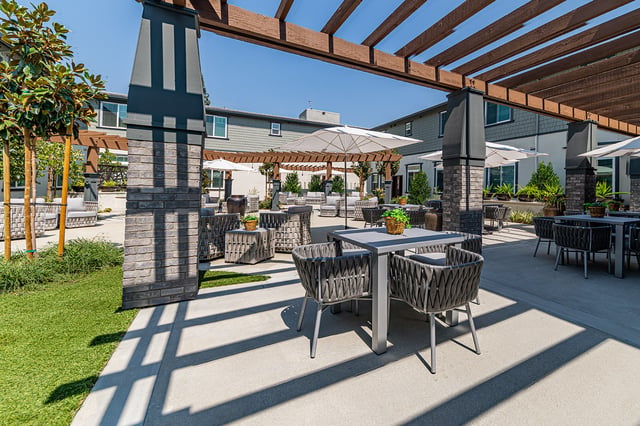 Outdoor seating area with shaded tables and chairs