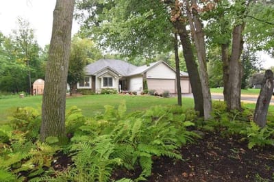 Exterior view of a single-story house surrounded by trees
