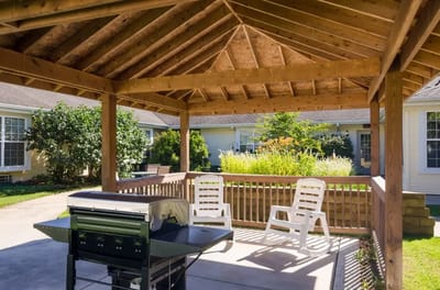 Outdoor gazebo area with seating in a landscaped garden