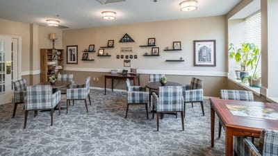 Common area with tables and chairs in bright interior