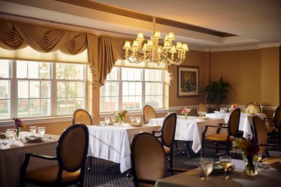 Elegant dining room setup with tables and floral arrangements