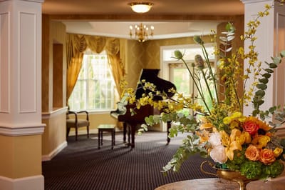 Bright common area with flowers and piano