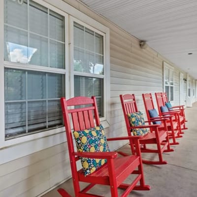 Row of red rocking chairs on a porch