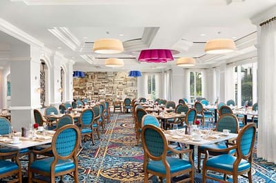 Dining room with colorful lighting and tables set for meals