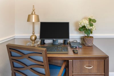 A furnished workspace with a computer and flowers