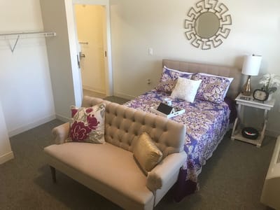 A well-furnished private resident room with bed and seating area