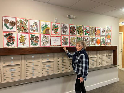 A resident showcasing art in a common area