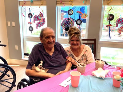 Resident enjoying an activity with staff member in a lively common area