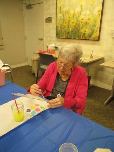 Resident painting at an activity table