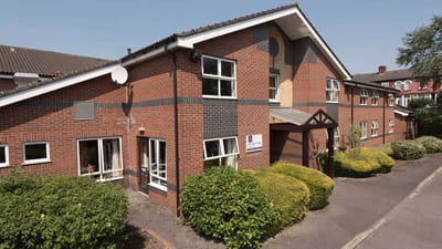 Exterior view of Wellington Lodge facility with garden