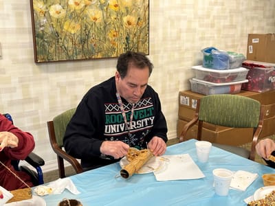 Resident engaged in craft activity inside the facility