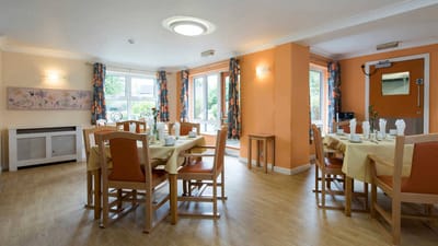 Bright dining room with tables set for meals