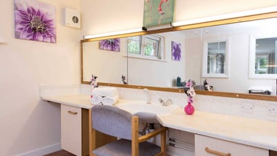 A well-decorated interior bathroom with flowers and towels.